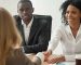 Job interview handshake with smiling professionals.